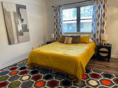 温泉城Lucky #9 Hot Springs的一间卧室配有一张带黄色床罩的床和窗户