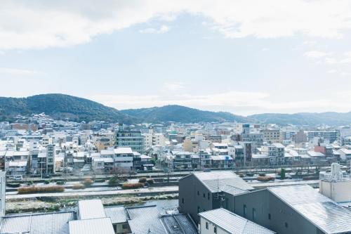 京都Fauchon Hotel Kyoto - A MEMBER OF THE LEADING HOTELS OF THE WORLD的享有拥有建筑和山脉的城市美景