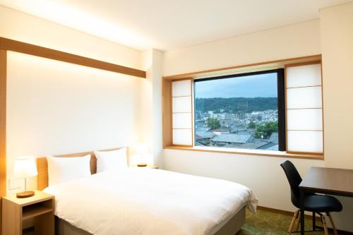 京都初音(はつね)的一间卧室配有一张床、一张书桌和一个窗户。