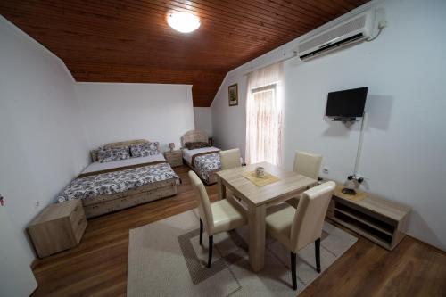 蒂瓦特帕维塞维奇公寓的卧室配有一张床和一张桌子及椅子