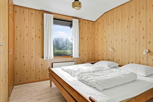 TranekærBeautiful Holiday Home From 1978的一间卧室设有一张带木墙的大床