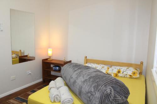 特拉曼达伊Apartamento à Beira-Mar e Centro Tramandaí Frente calçadão的一间卧室配有一张床、一张桌子和一面镜子