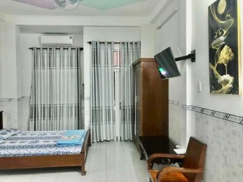 归仁Nhà Nghỉ Hải Đăng的一间卧室配有一张床,并在一间客房内配有电视。