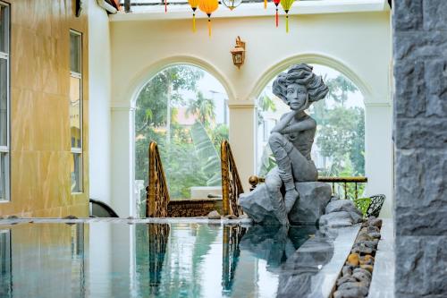 顺化HELLO VILLA & SPA的一座房子中游泳池中间的雕像