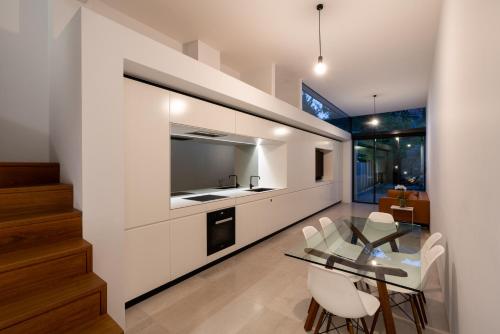 悉尼Paddington House的厨房以及带玻璃桌和椅子的用餐室