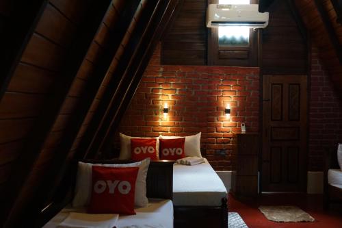 锡吉里亚Another World Hostel Sigiriya的一间设有两张床和砖墙的房间