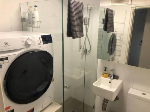 悉尼Lovely refurbished 1 bed near marina + parking的一间带洗衣机和水槽的浴室