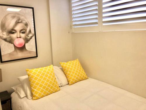 悉尼Lovely refurbished 1 bed near marina + parking的卧室,有一张画有粉色舌头的女人的照片