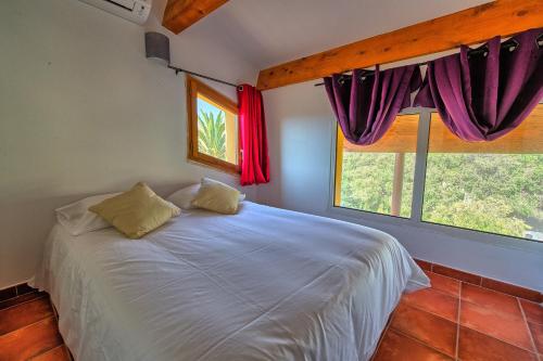 卡尔维Casa Vecchia rooms + apartments的卧室配有白色的床和2扇窗户。