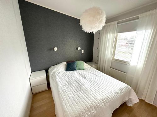 卡亚尼Lumikukka Vuokatti的卧室配有带白色棉被的床