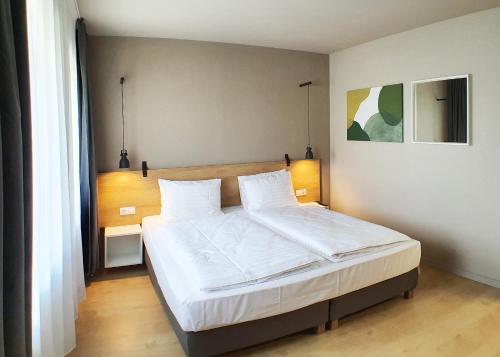 萨图马雷Marida Hotel的一间卧室配有一张带白色床单的大床