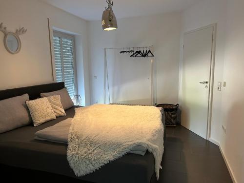 帕绍Homequartier Passau的卧室配有一张沙发,上面有白色的毯子