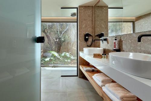 阿默达拉-伊拉克利翁Sentido Amounda Bay的一间带两个盥洗盆的浴室和一个大窗户