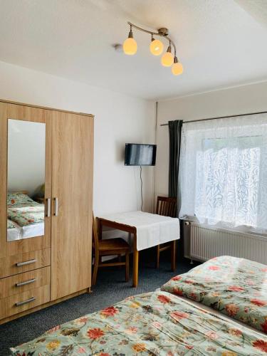多尔努姆Hotel Pension Schienfatt am Dornumersieler Tief的酒店客房设有两张床、一张桌子和一面镜子