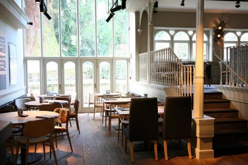 戴德姆密斯欧米斯酒店的餐厅设有桌椅和大窗户。