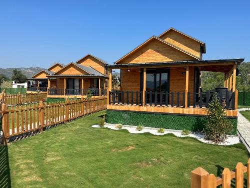 达拉曼Lake house kayacık Resort的木栅栏后面的一排小屋