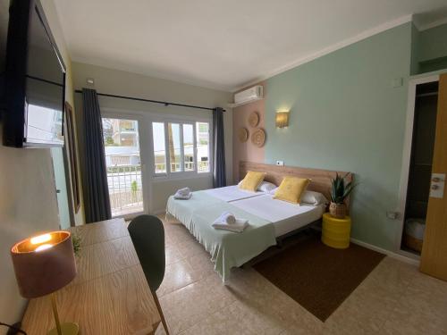 帕尔马海滩巴利阿里群岛旅馆的卧室配有白色的床和桌子