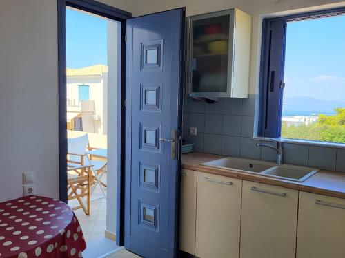 VagiaAegina Vagia Sea Breeze Vacation Villa的厨房设有通往阳台的门