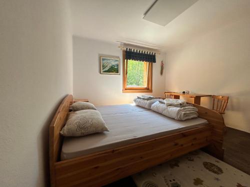 特尔日奇Mountain hut Dom pod Storžičem的一间卧室配有一张带枕头的木床