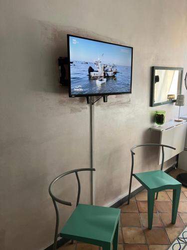 萨尔扎纳马列塔旅馆的墙上的平面电视,配有两把椅子和一张桌子
