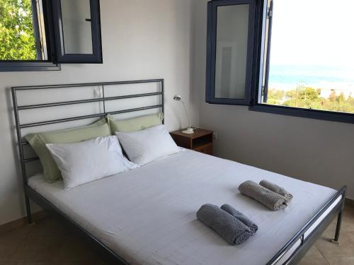 VagiaAegina Vagia Sea Breeze Vacation Villa的一间卧室配有一张床,上面有两条毛巾