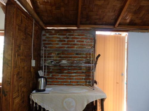 武吉拉旺Magpie homestay & jungle trekking的厨房配有砖墙桌子