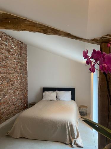 德塞尔Hoeve De Kleinheide的一间卧室设有一张床和砖墙