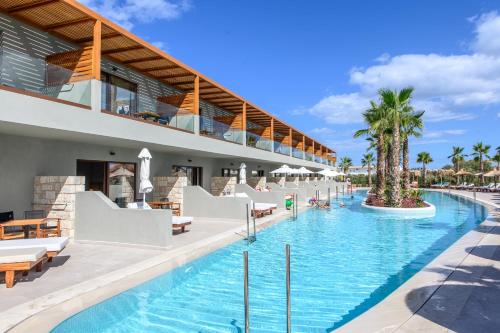 赫索尼索斯Stella Palace Aqua Park Resort的一个带躺椅和棕榈树的度假游泳池