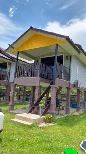 Kuala KeraiDusun Rimbun Agro Farmstay的房屋的一侧设有大甲板