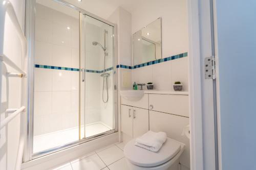 沃金Spacious Apartment in Woking Town Centre的带淋浴和卫生间的白色浴室
