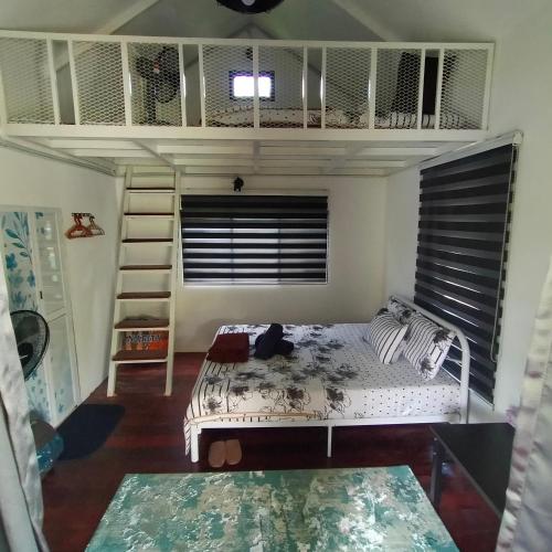 Kuala KeraiDusun Rimbun Agro Farmstay 3的一间卧室配有一张双层床和梯子