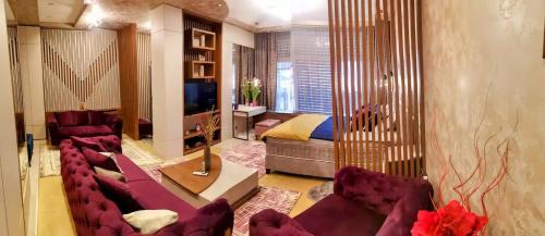 克拉列沃HELGA apartmani BOSS i PRESIDENT的一间带紫色家具的客厅和一间卧室