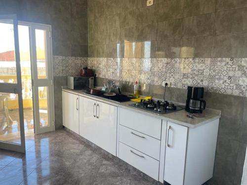 塔巴卡Villa Belle-Vue的厨房配有白色橱柜和台面