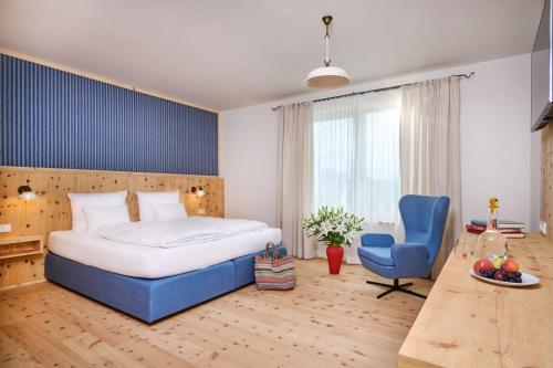施特劳宾Hotel Der Einrichter的一间卧室配有一张大床和一张蓝色椅子