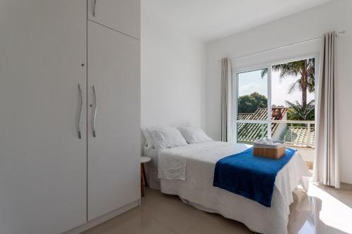 尼泰罗伊Casa incrível com 04 suítes - 5 min de Itacoatiara的白色的卧室设有床和窗户