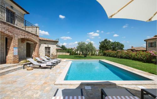 帕泽纳蒂奇Villa Megi的一座带椅子的庭院和一座建筑中的游泳池