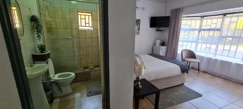 马翁Thamalakane guest house的浴室设有床、卫生间和水槽。