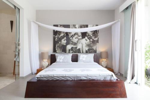 塞米亚克Villa KMEA 4的一间卧室配有一张带一张三人海报的床