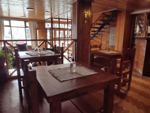 圣卡洛斯-德巴里洛切Hotel Curru Leuvu的餐厅设有木桌、椅子和窗户。