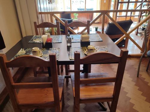 圣卡洛斯-德巴里洛切Hotel Curru Leuvu的餐桌、椅子和餐桌,餐具