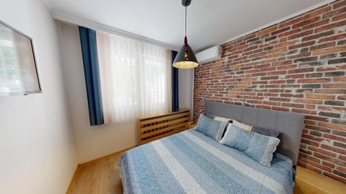 索非亚Апартамент в топ център София 5 Corners的一间卧室设有砖墙和一张床
