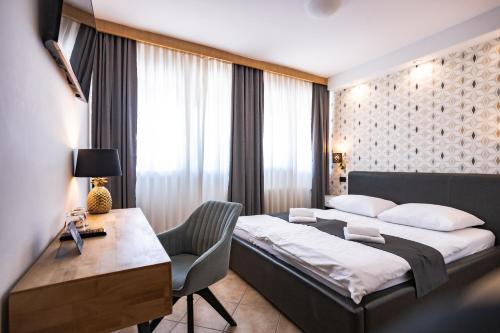卢布尔雅那Ljubljana Resort Hotel & Camping的酒店客房带一张床铺、一张书桌和一间卧室