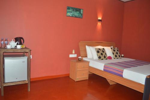 蒂瑟默哈拉默Amazon Cabanas的一间卧室拥有橙色的墙壁,配有一张床和床头柜