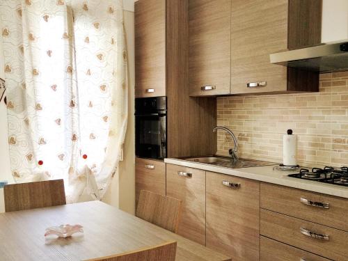 马奥莱La Torre的厨房配有木制橱柜和带水槽的桌子。