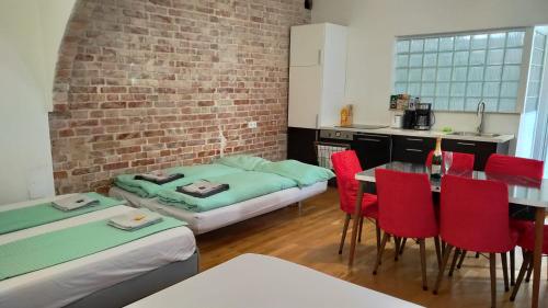 维也纳CozyNite Premium Apartment Stadthalle的厨房配有床和一张带红色椅子的桌子