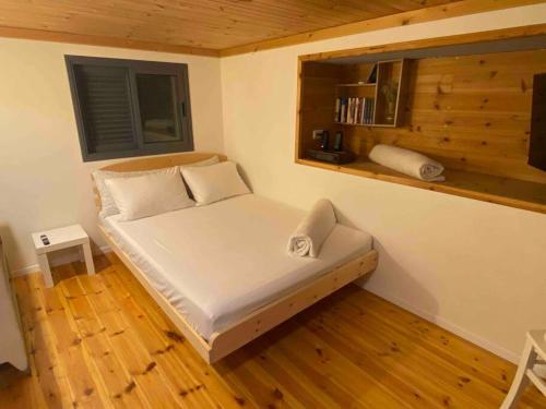 Kefar DaniyyelBit cabin near the airport的铺有木地板的客房内的一张小床