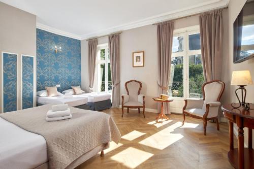 布鲁瓦法国和盖斯酒店的酒店客房,配有两张床和两把椅子