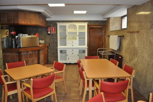 纳瓦莱诺Hostal La Tablada的一间设有两张桌子和红色椅子的用餐室