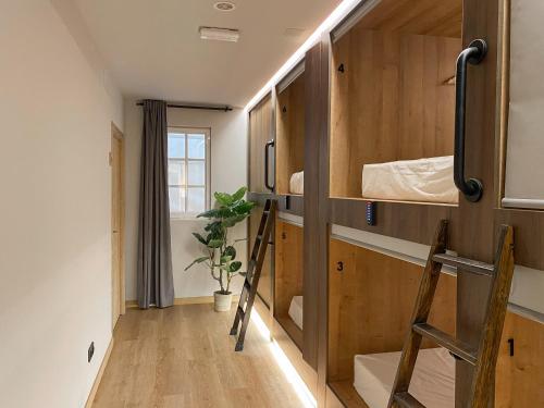 瓦伦西亚The POD Suite Hostel的小房间设有双层床和梯子