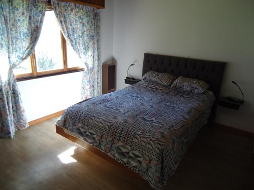 圣马丁德洛斯Casa Perez的一间卧室配有床和带窗帘的窗户